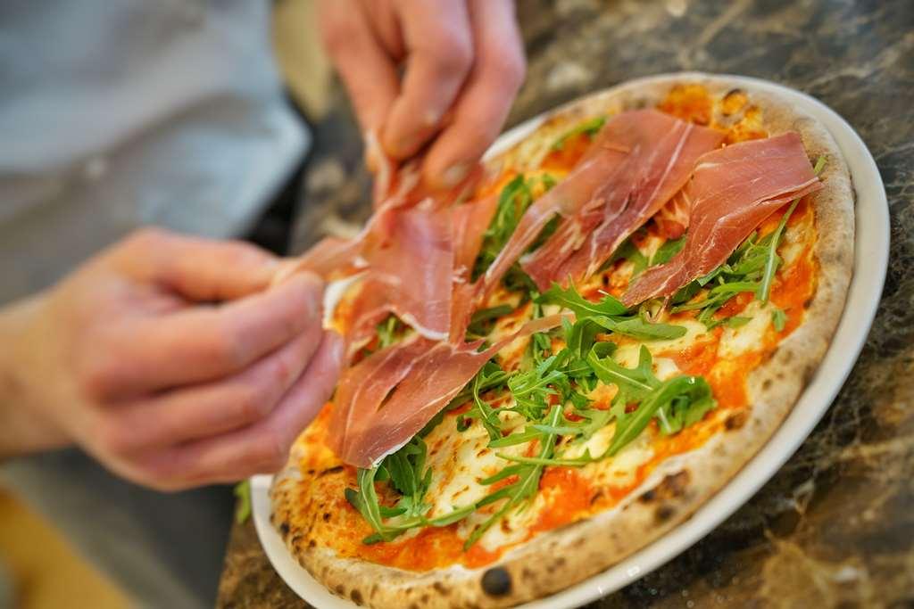 Vila Vita Rosenpark Marburg ภายนอก รูปภาพ Pizza being topped with prosciutto